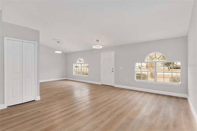 unfurnished room with light hardwood / wood-style flooring and vaulted ceiling