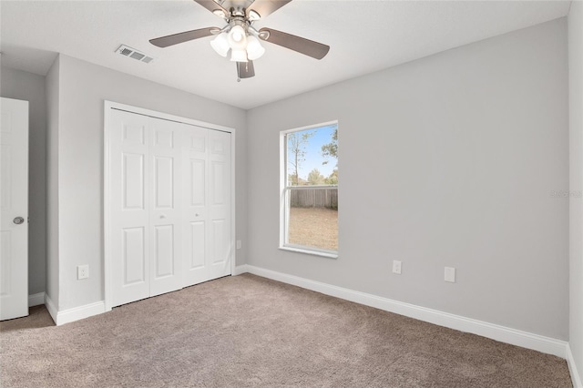 unfurnished bedroom featuring carpet, ceiling fan, and a closet