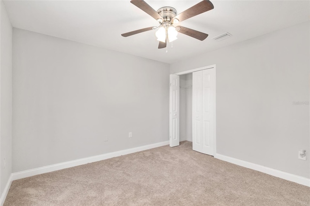 unfurnished bedroom featuring light carpet, ceiling fan, and a closet