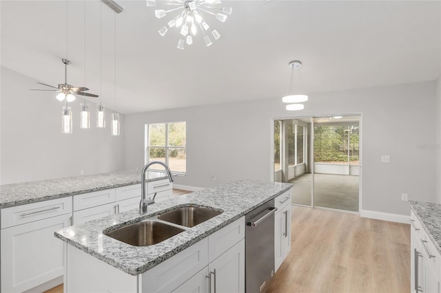 kitchen with white cabinetry, stainless steel dishwasher, a center island with sink, and decorative light fixtures