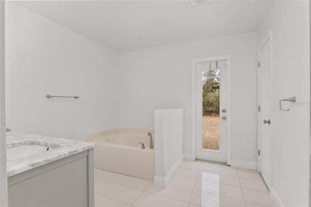 bathroom with tile patterned floors, a bathtub, and vanity