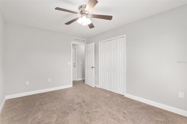 unfurnished bedroom featuring carpet floors, a closet, and ceiling fan