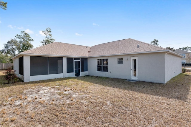 rear view of property featuring a yard and a sunroom