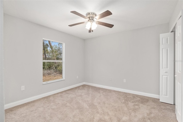 unfurnished room with ceiling fan and light carpet