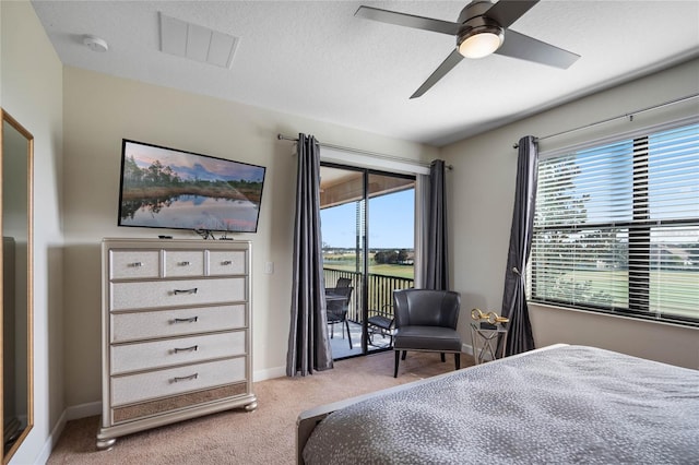 carpeted bedroom featuring ceiling fan, access to exterior, multiple windows, and a textured ceiling