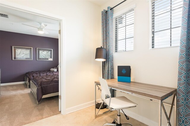 carpeted office with baseboards, visible vents, and ceiling fan