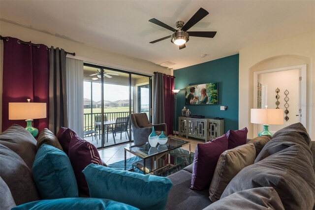 living area featuring ceiling fan and tile patterned flooring