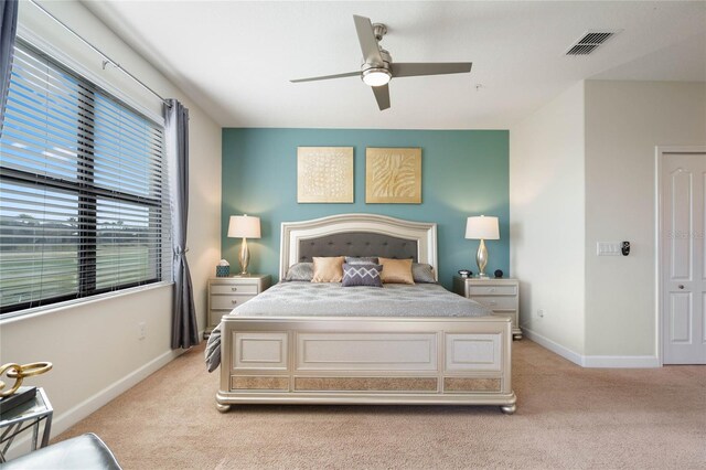bedroom featuring baseboards, visible vents, and light carpet