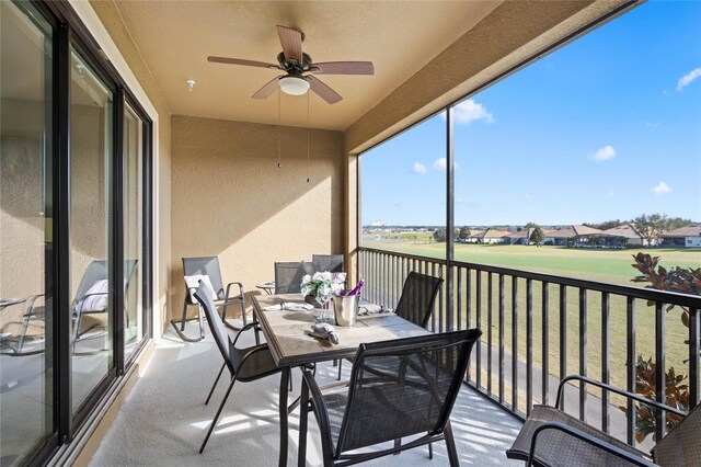 sunroom / solarium with outdoor dining area and a ceiling fan