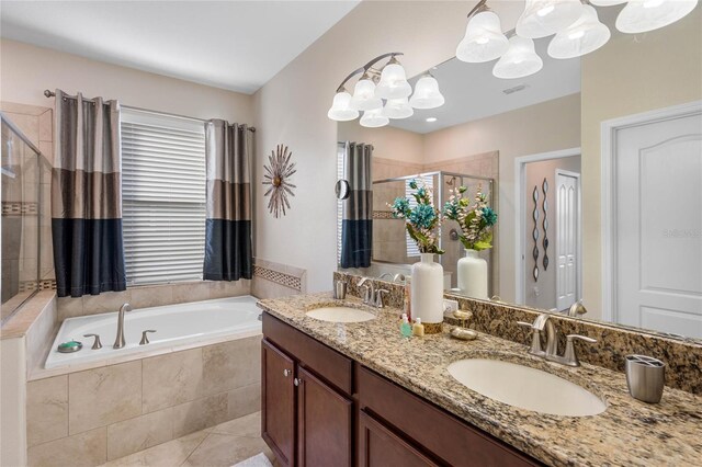 full bathroom with a shower stall, a bath, a sink, and an inviting chandelier