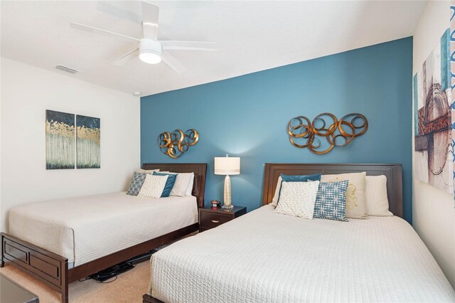 carpeted bedroom with visible vents and a ceiling fan
