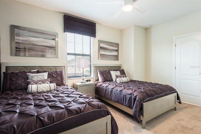 bedroom with a ceiling fan and light carpet