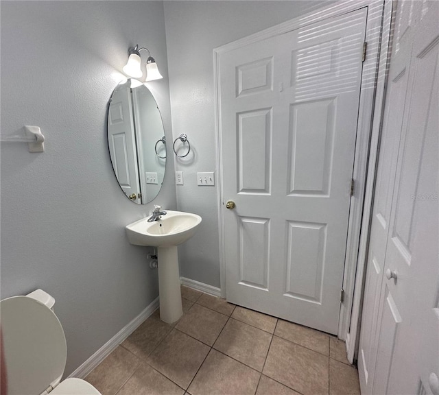 bathroom featuring sink, toilet, and tile patterned flooring