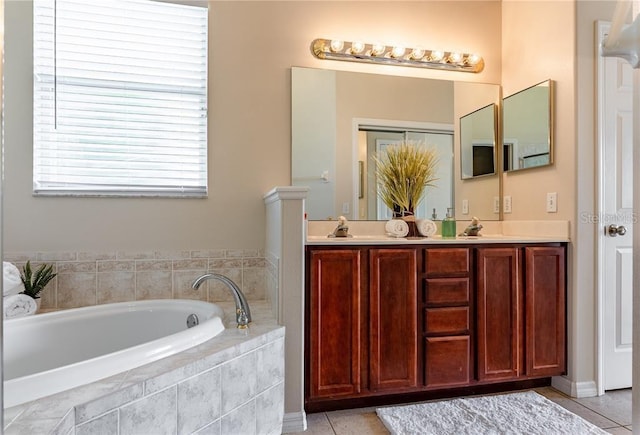 bathroom featuring tile patterned flooring, vanity, and tiled tub