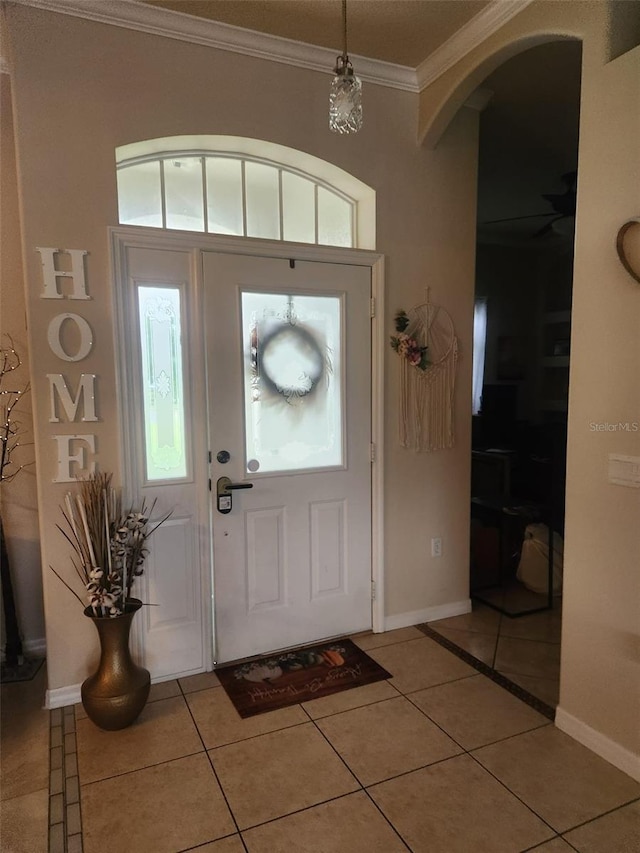 tiled entrance foyer featuring crown molding