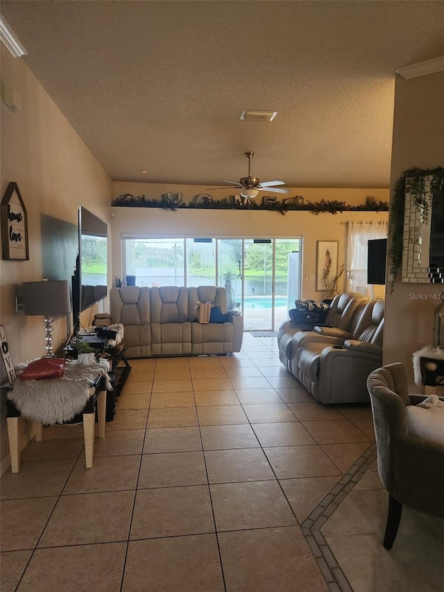 living room featuring light tile patterned flooring, ceiling fan, and a textured ceiling