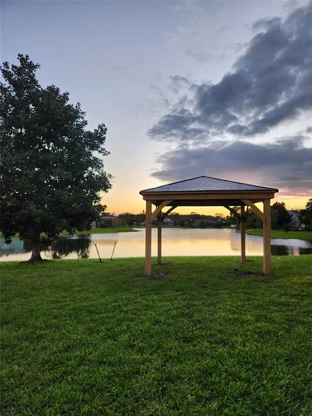 view of property's community featuring a gazebo, a lawn, and a water view