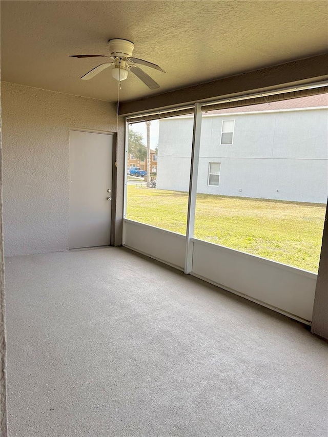 unfurnished sunroom featuring ceiling fan