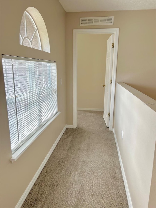 corridor featuring light colored carpet