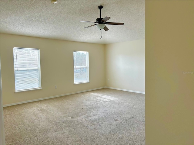 carpeted empty room featuring ceiling fan and a textured ceiling