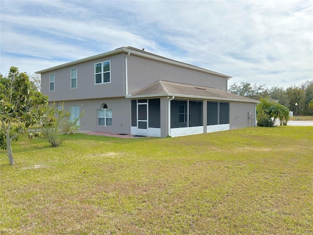 back of house with a lawn and a sunroom