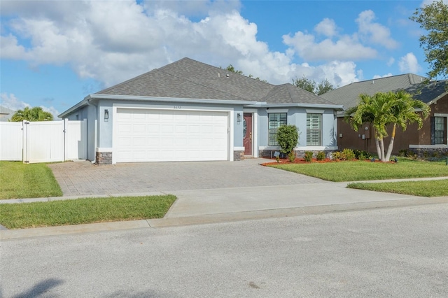 ranch-style house featuring a garage and a front lawn