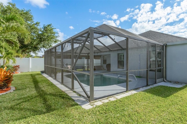 rear view of house featuring a patio, a lanai, a fenced in pool, and a lawn