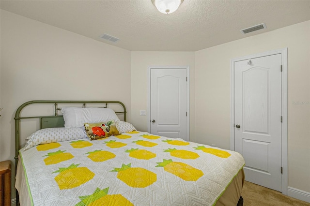 bedroom featuring carpet flooring and a textured ceiling