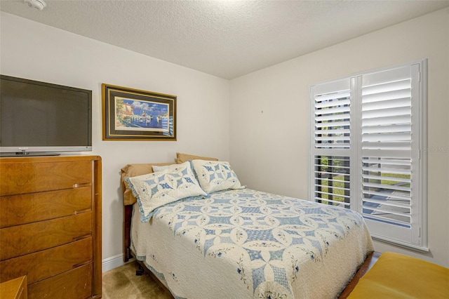 bedroom featuring light colored carpet and a textured ceiling