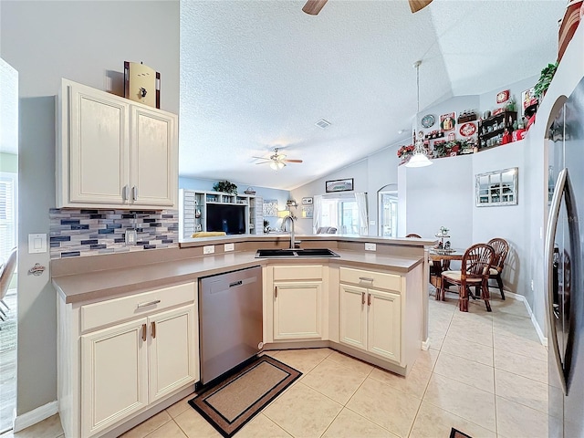 kitchen featuring lofted ceiling, sink, ceiling fan, appliances with stainless steel finishes, and kitchen peninsula