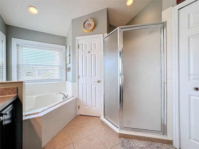 bathroom with vanity, shower with separate bathtub, tile patterned flooring, and a textured ceiling