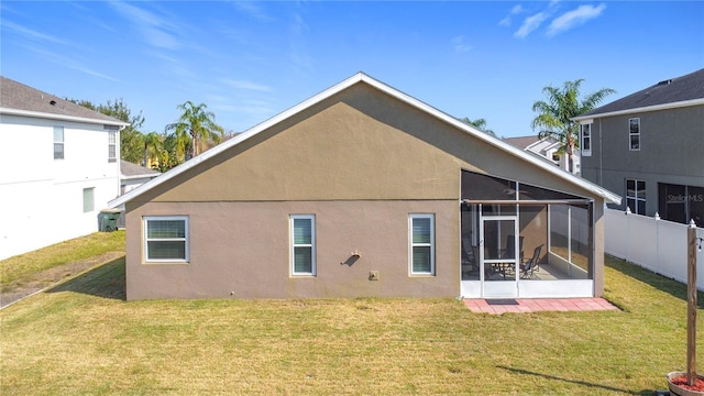 back of house with a lawn and a sunroom