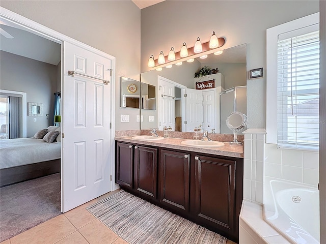 bathroom with tile patterned floors, separate shower and tub, vanity, and a wealth of natural light