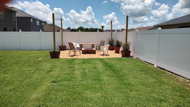 view of yard featuring a fenced backyard and a fire pit