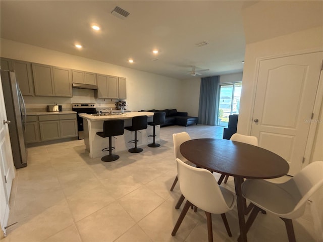 dining space featuring sink, light tile patterned floors, and ceiling fan