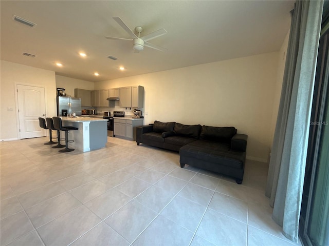 tiled living room featuring ceiling fan