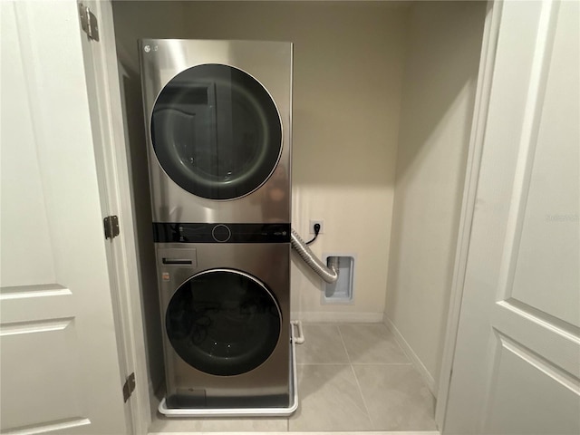 clothes washing area with stacked washer / dryer and light tile patterned floors