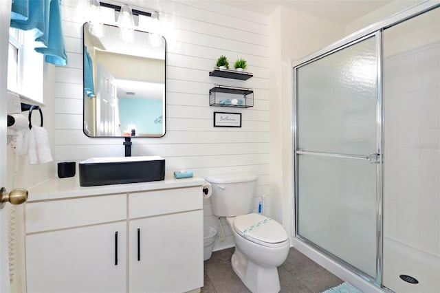 bathroom with walk in shower, vanity, tile patterned floors, and toilet