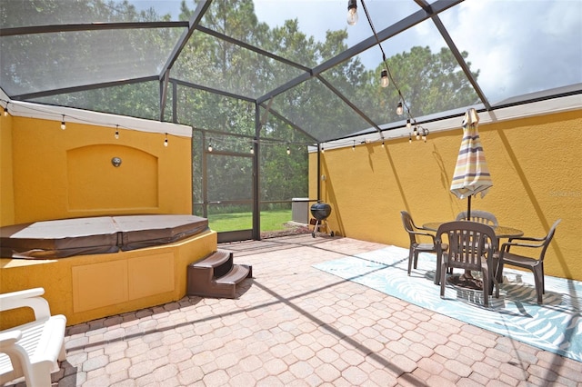 view of patio featuring a hot tub and a lanai