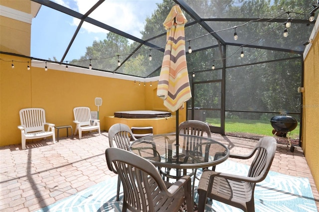 view of patio / terrace featuring a hot tub and a lanai