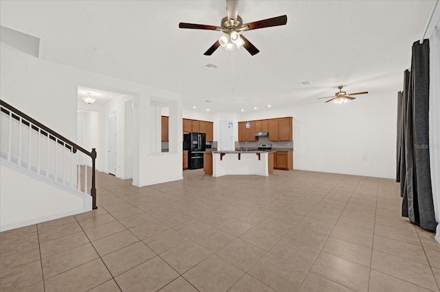 unfurnished living room with ceiling fan and light tile patterned flooring