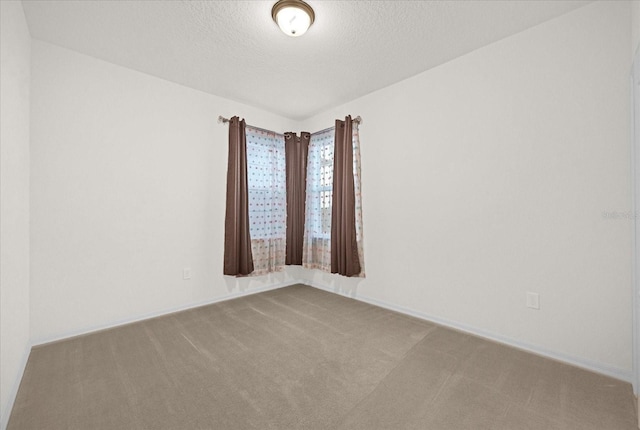 carpeted empty room with a textured ceiling