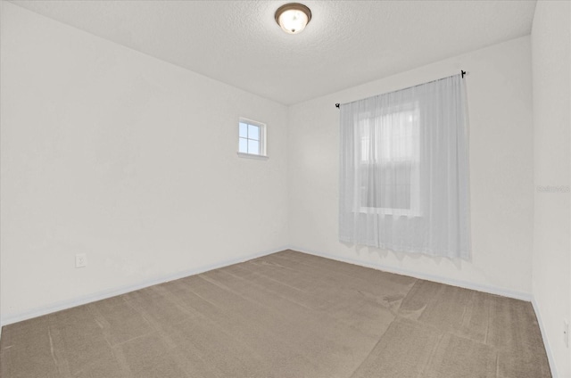 unfurnished room with light colored carpet and a textured ceiling