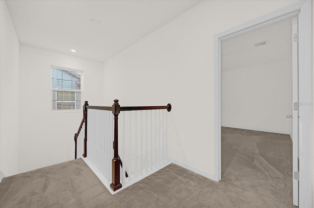 hallway featuring light colored carpet