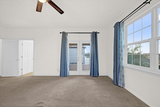 carpeted empty room with a wealth of natural light, ceiling fan, and french doors