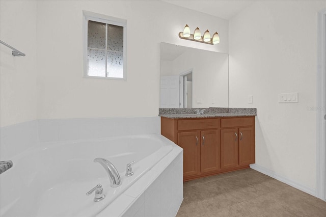 bathroom featuring tile patterned floors, vanity, and tiled tub