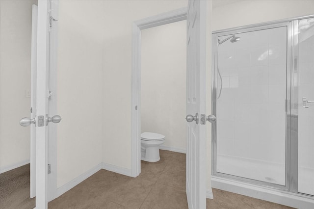 bathroom featuring an enclosed shower, tile patterned floors, and toilet