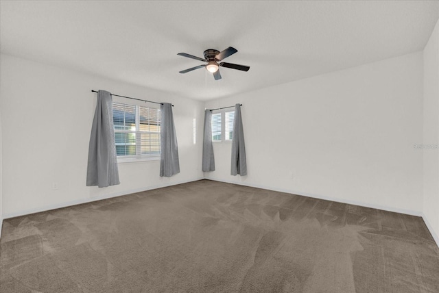 carpeted spare room featuring ceiling fan