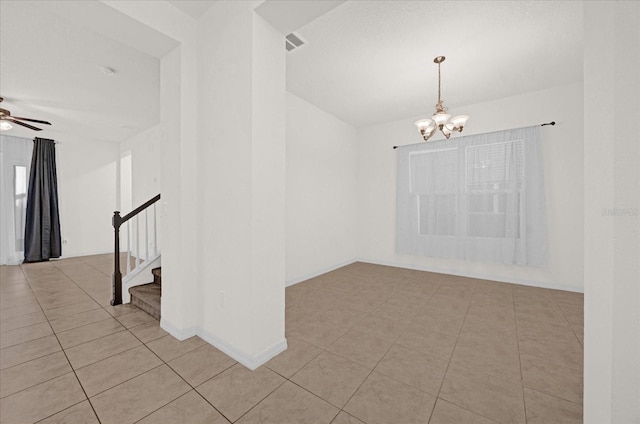 empty room featuring light tile patterned flooring and ceiling fan with notable chandelier