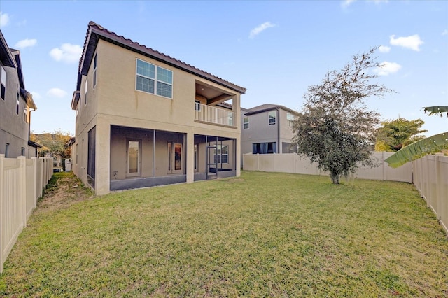 back of house with a balcony and a yard